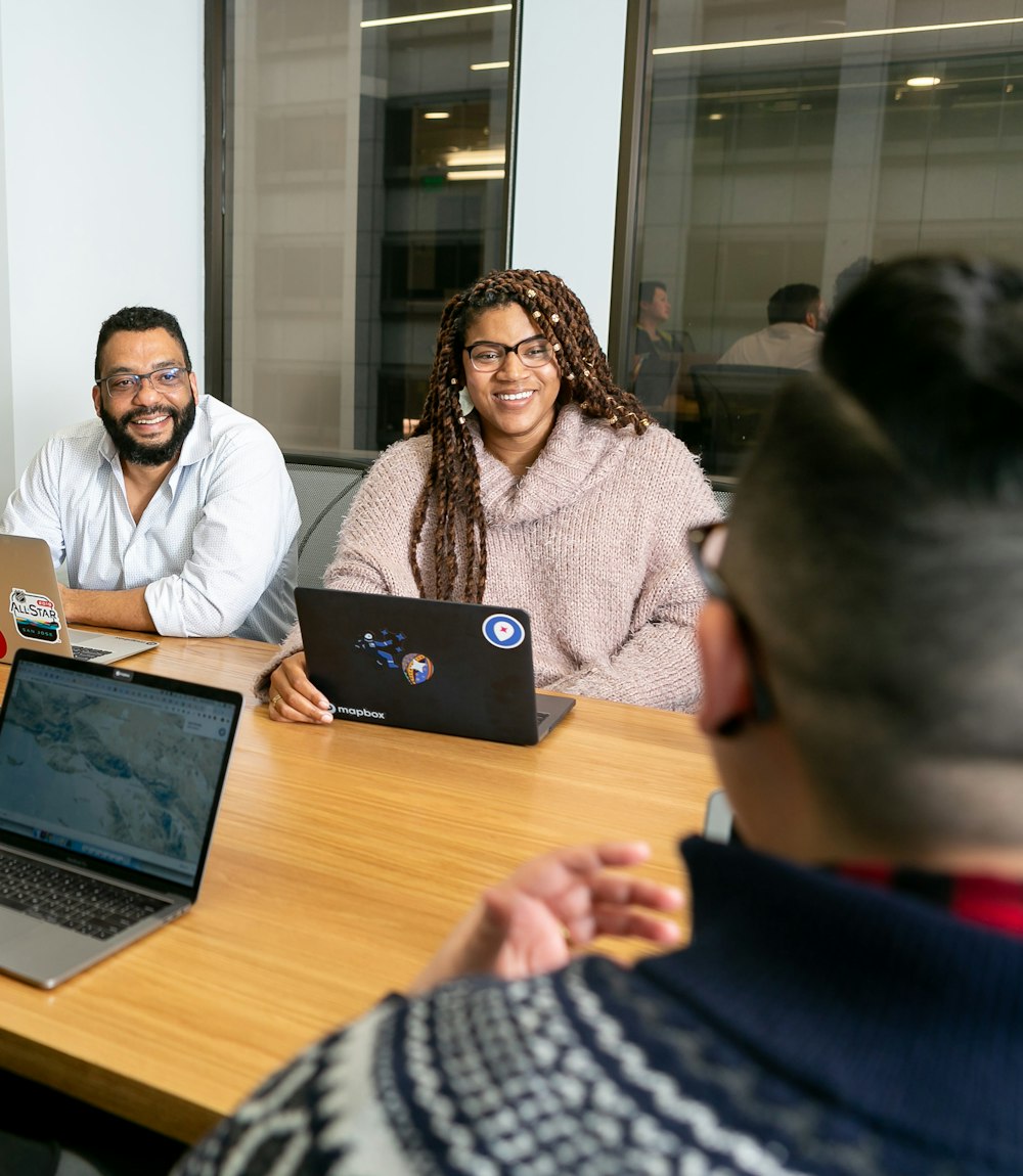 Small team working together on laptops around a meeting table